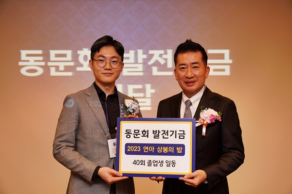 이정욱 동문회장(우)이 40회 졸업생의 발전기금을 전달받고 있다.