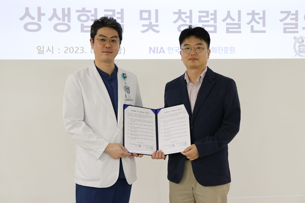 18일 열린 상생협력 및 청렴실천 결의식에서 서울대치과병원 양일형 교수(좌)와 NIH 김성현 수석이 협약서를 교환하고 있다.