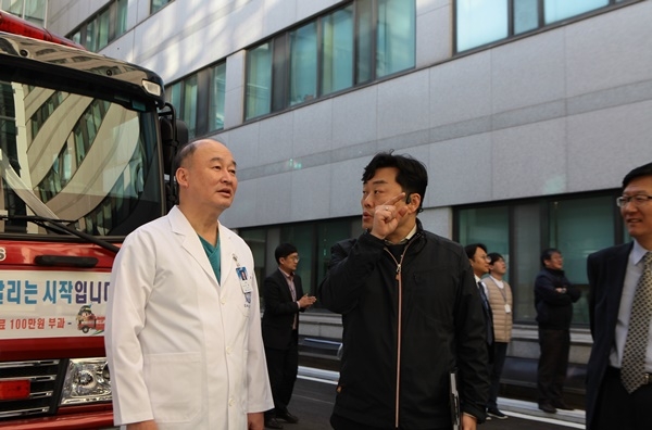 구영 서울대치과병원장(왼쪽)이 종로소방서 김현성 대원에게 소방훈련과 관련하여 설명을 듣고 있다.