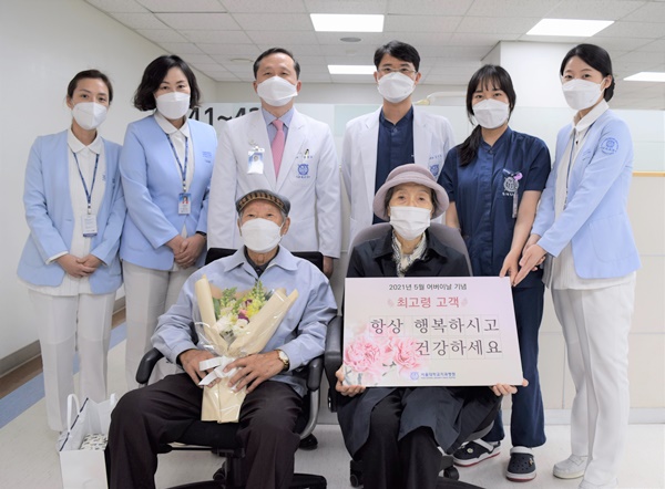 설양조 과장(뒷줄 왼쪽에서 3번째)과 김선영 치의료관리담당 교수(뒷줄 왼쪽에서 4번째)가 치주과를 내원한 최고령 고객에게 꽃다발을 증정하고 있다.