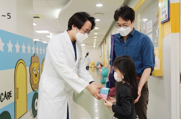 어린이날, 소아치과 김현태 교수(왼쪽)가 진료 후 어린이날 선물을 증정하고 있다.