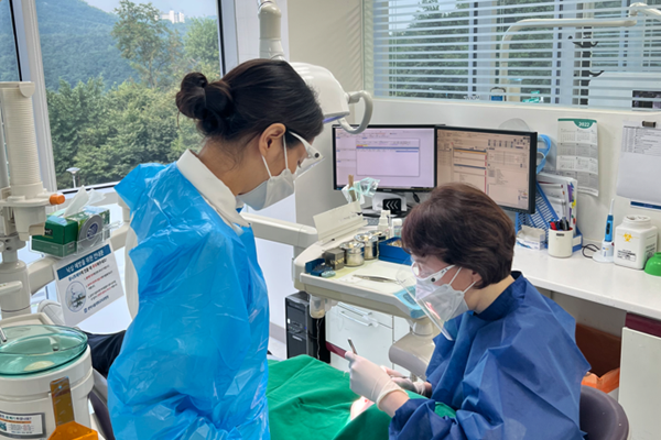 관악서울대치과병원 치과보존과 조낙연 교수(오른쪽)가 환자를 진료하고 있다.