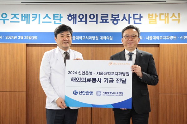 정상혁 신한은행장(오른쪽)이 이용무 서울대치과병원장에게 해외의료봉사 기금을 전달하고 있다.